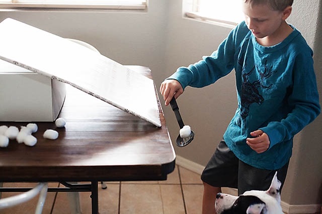 Snowball roll game using cotton balls from All for the Boys blog